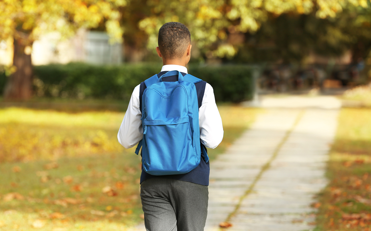 Student with backpack walking pathway